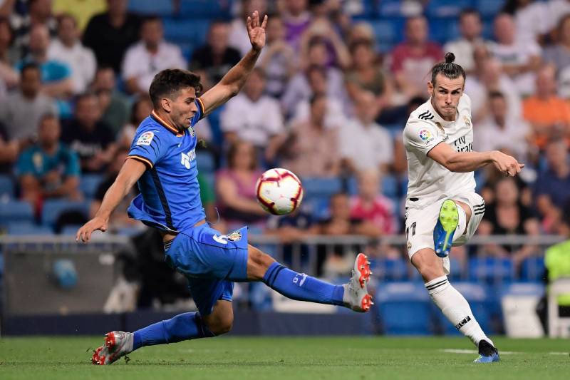 Real Madrid's Welsh forward Gareth Bale kicks the ball past Getafe's Uruguayan defender Leandro Cabrera (L) during the Spanish League football match between Real Madrid and Getafe at the Santiago Bernabeu stadium in Madrid on August 19, 2018. (Photo by JAVIER SORIANO / AFP)        (Photo credit should read JAVIER SORIANO/AFP/Getty Images)