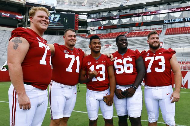 Alabama Crimson Tide quarterback Tua Tagovailoa (13) poses for a photo with offensive lineman Matt Womack (77), Ross Pierschbacher (71), Lester Cotton Sr. (66), and Jonah Williams (73) before a NCAA college football practice, Saturday, Aug. 4, 2018, in Tuscaloosa, Ala. (AP Photo/Butch Dill)