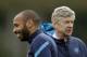 Arsenal's on loan former player, and the club's all time highest scorer, Thierry Henry, left, stands near the club's French manager Arsene Wenger during a training session at the club's facilities in London Colney, England, Tuesday, Feb. 14, 2012. Arsenal are due to play AC Milan in the first leg of their Champions League last 16 soccer match in Milan on Wednesday. (AP Photo/Matt Dunham)