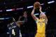Los Angeles Lakers guard Lonzo Ball, right, attempts a shot ahead of Denver Nuggets forward Paul Millsap during the second half of an NBA basketball game in Los Angeles, Tuesday, March 13, 2018. (AP Photo/Kelvin Kuo)