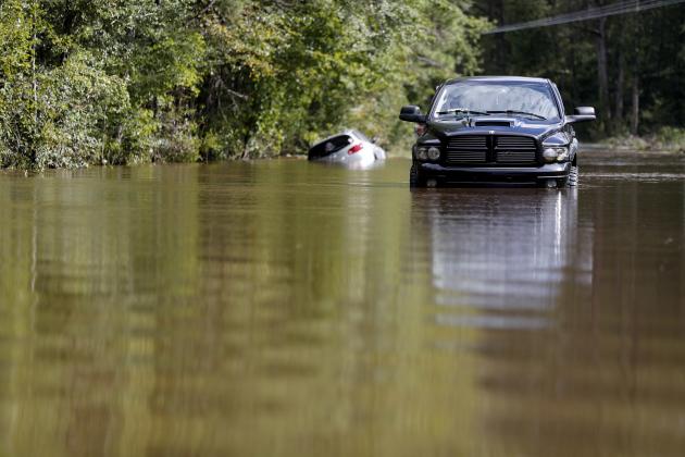 Cars sit abandoned on a flooded street in the aftermath of Hurricane Florence in Lillington, N.C., Tuesday, Sept. 18, 2018. (AP Photo/David Goldman)