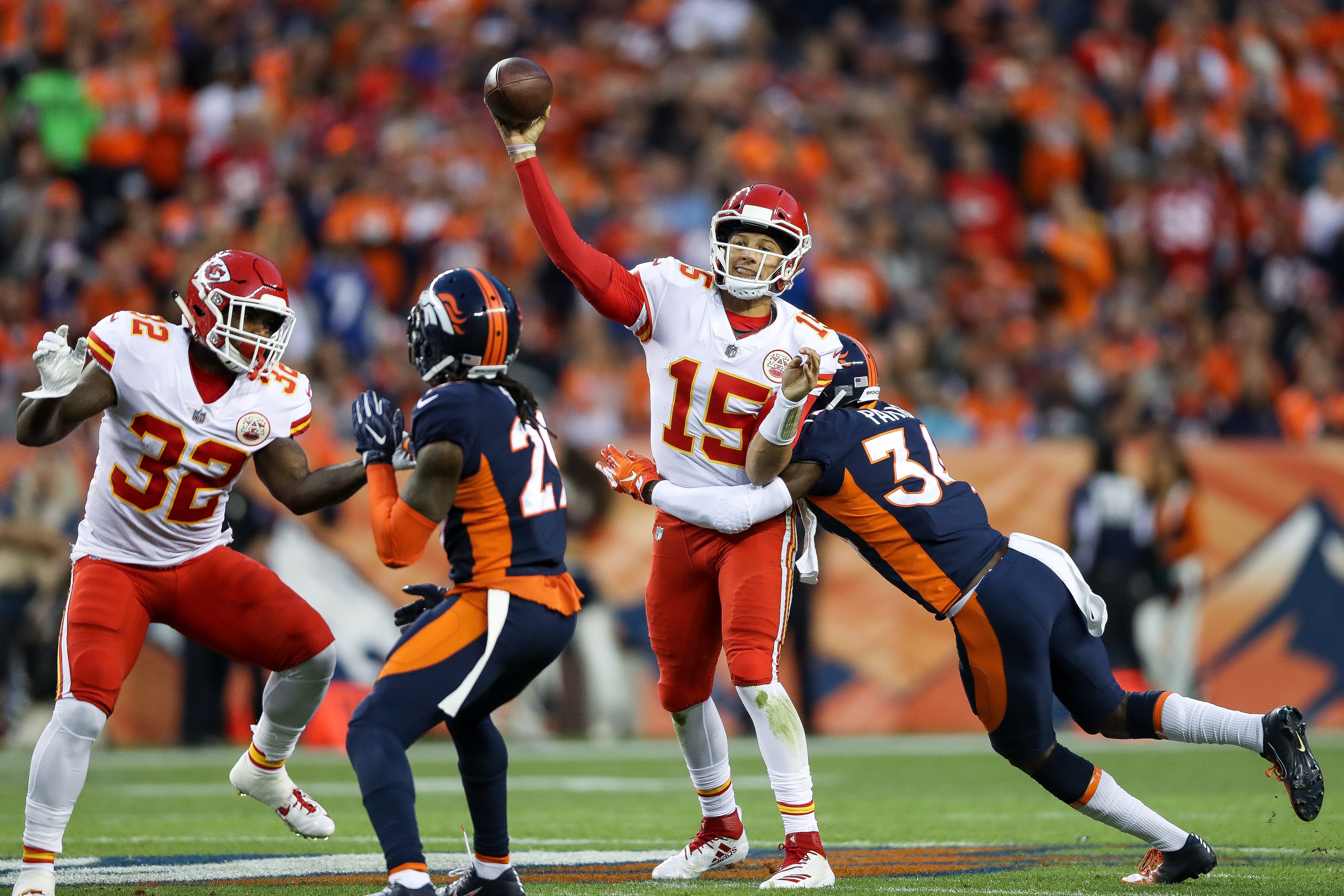 DENVER, CO - OCTOBER 1:  Quarterback Patrick Mahomes #15 of the Kansas City Chiefs is hit by defensive back Will Parks #34 of the Denver Broncos as he throws against the Kansas City Chiefs in the first half  at Broncos Stadium at Mile High on October 1, 2018 in Denver, Colorado. (Photo by Matthew Stockman/Getty Images)