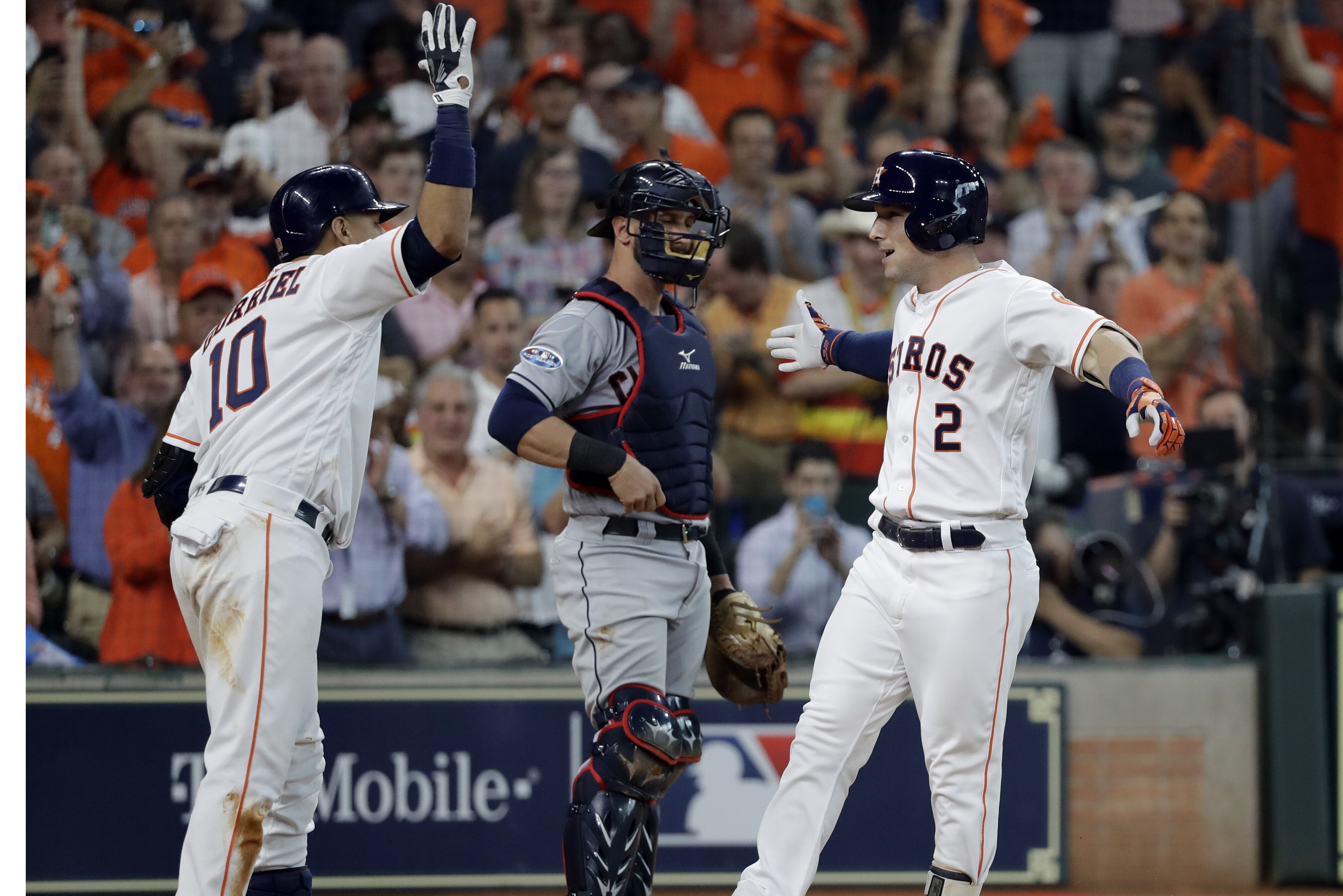 Houston Astros' Alex Bregman (2) celebrates his solo home run with teammate Yuli Gurriel (10) as Cleveland Indians catcher Yan Gomes, center, looks on during the fourth inning in Game 1 of an American League Division Series baseball game against the Cleveland Indians, Friday, Oct. 5, 2018, in Houston. (AP Photo/David J. Phillip)