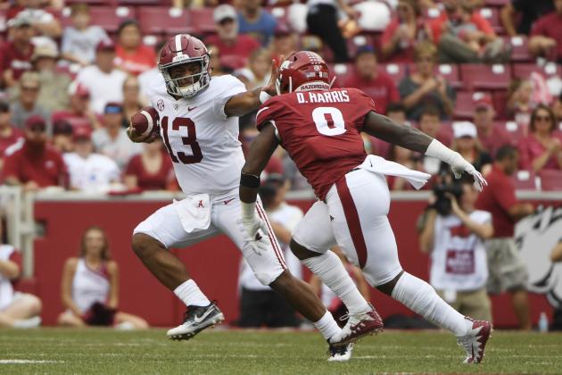 Alabama quarterback Tua Tagovailoa (13) tries to get away from Arkansas defender De'Jon Harris in the first half of an NCAA college football game Saturday, Oct. 6, 2018, in Fayetteville, Ark. (AP Photo/Michael Woods)