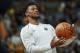 Injured Minnesota Timberwolves guard Jimmy Butler jokes with teammates during introductions before the team's NBA basketball game against the Denver Nuggets on Thursday, April 5, 2018, in Denver. (AP Photo/David Zalubowski)