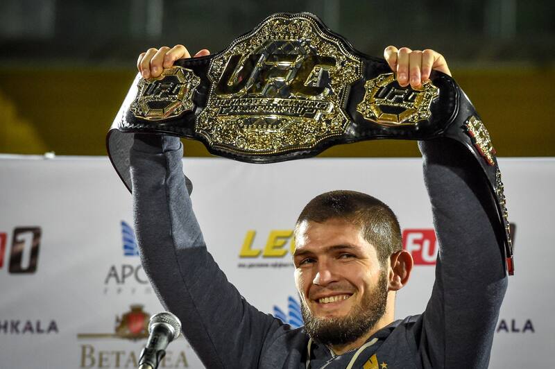 UFC lightweight champion Khabib Nurmagomedov of Russia raises his champions belt upon the arrival in Makhachkala on October 8, 2018. - Nurmagomedov defeated Conor McGregor of Ireland in their UFC lightweight championship bout by way of submission during the UFC 229 event inside T-Mobile Arena on October 6, 2018 in Las Vegas, Nevada. (Photo by Vasily MAXIMOV / AFP) (Photo credit should read VASILY MAXIMOV/AFP/Getty Images)