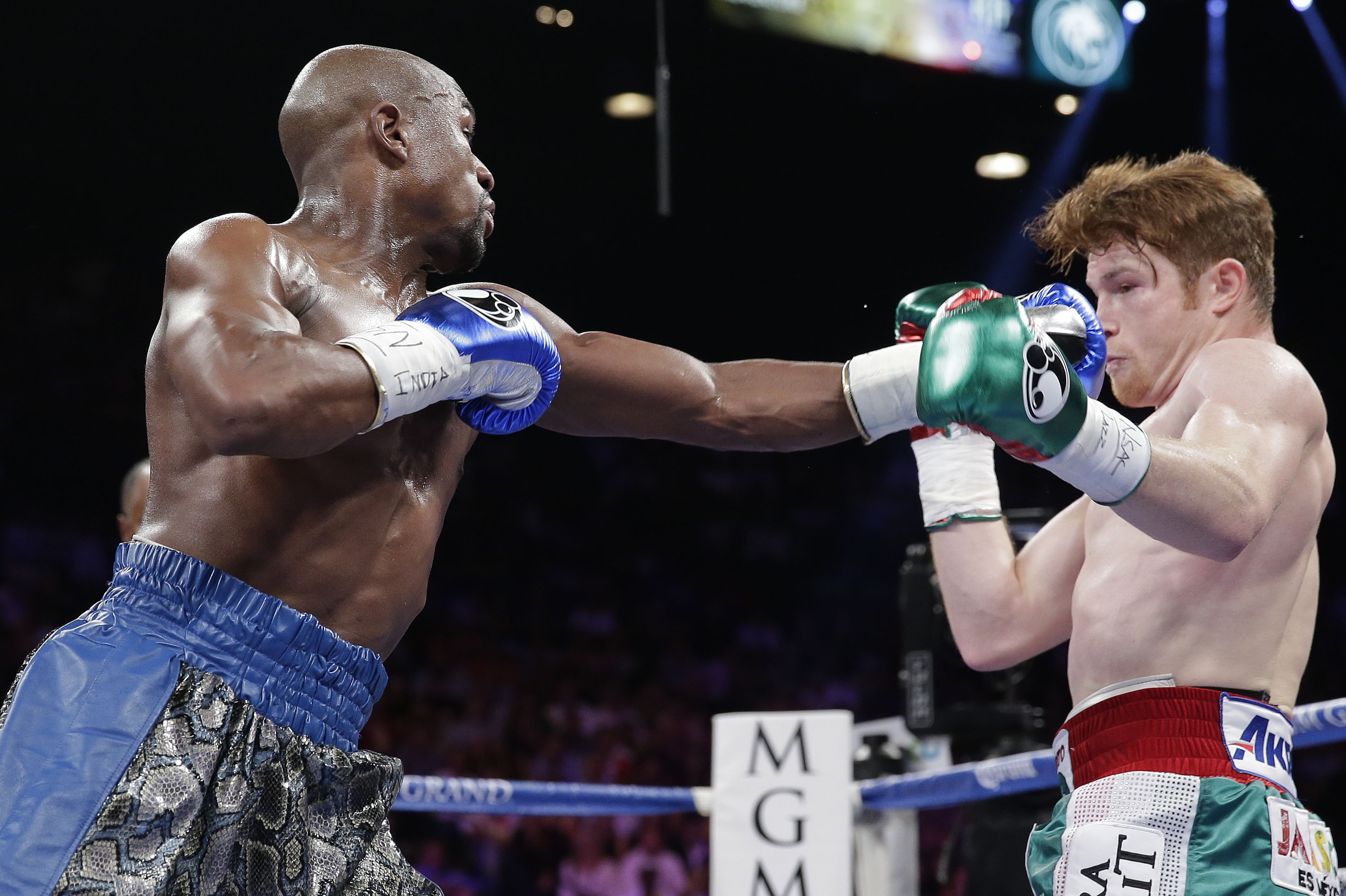 Floyd Mayweather Jr., left, throws a jab at Canelo Alvarez in the first round during a 152-pound title fight, Saturday, Sept. 14, 2013, in Las Vegas. (AP Photo/Eric Jamison)