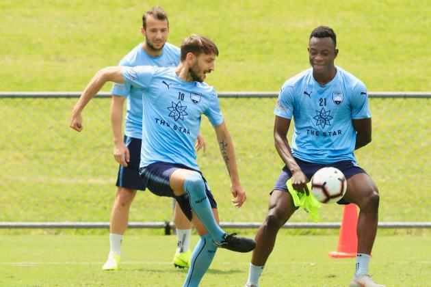 SYDNEY, AUSTRALIA - OCTOBER 22: Milos Ninkovoic of Sydney FC passes the ball as Charles Lokolingoy (R) looks on during a Sydney FC A-League media opportunity at Macquarie Uni on October 22, 2018 in Sydney, Australia. (Photo by Mark Evans/Getty Images)