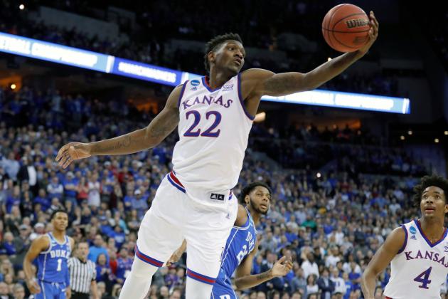 FILE - In this March 25, 2018, file photo, Kansas' Silvio De Sousa reaches for a rebound during the first half of a regional final game against Duke in the NCAA men's college basketball tournament, in Omaha, Neb. Kansas and North Carolina State are the latest schools to be swept up in a bribery scandal involving college basketball. A rewritten indictment released Tuesday, April 10, 2018, in New York alleges that an Adidas representative, who no longer works for the company, arranged for payments to parents of athletes willing to commit to the schools. No players are directly named, but specific details make clear the indictment is describing former North Carolina State star Dennis Smith Jr. and Kansas player Silvio De Sousa.(AP Photo/Charlie Neibergall, File)