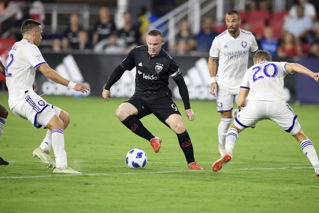 D.C. United forward Wayne Rooney (9) dribbles the ball against Orlando City midfielder Oriol Rosell (20) and defender Shane O'Neill, left, during the first half of an MLS soccer match, Sunday, Aug. 12, 2018, in Washington. (AP Photo/Nick Wass)
