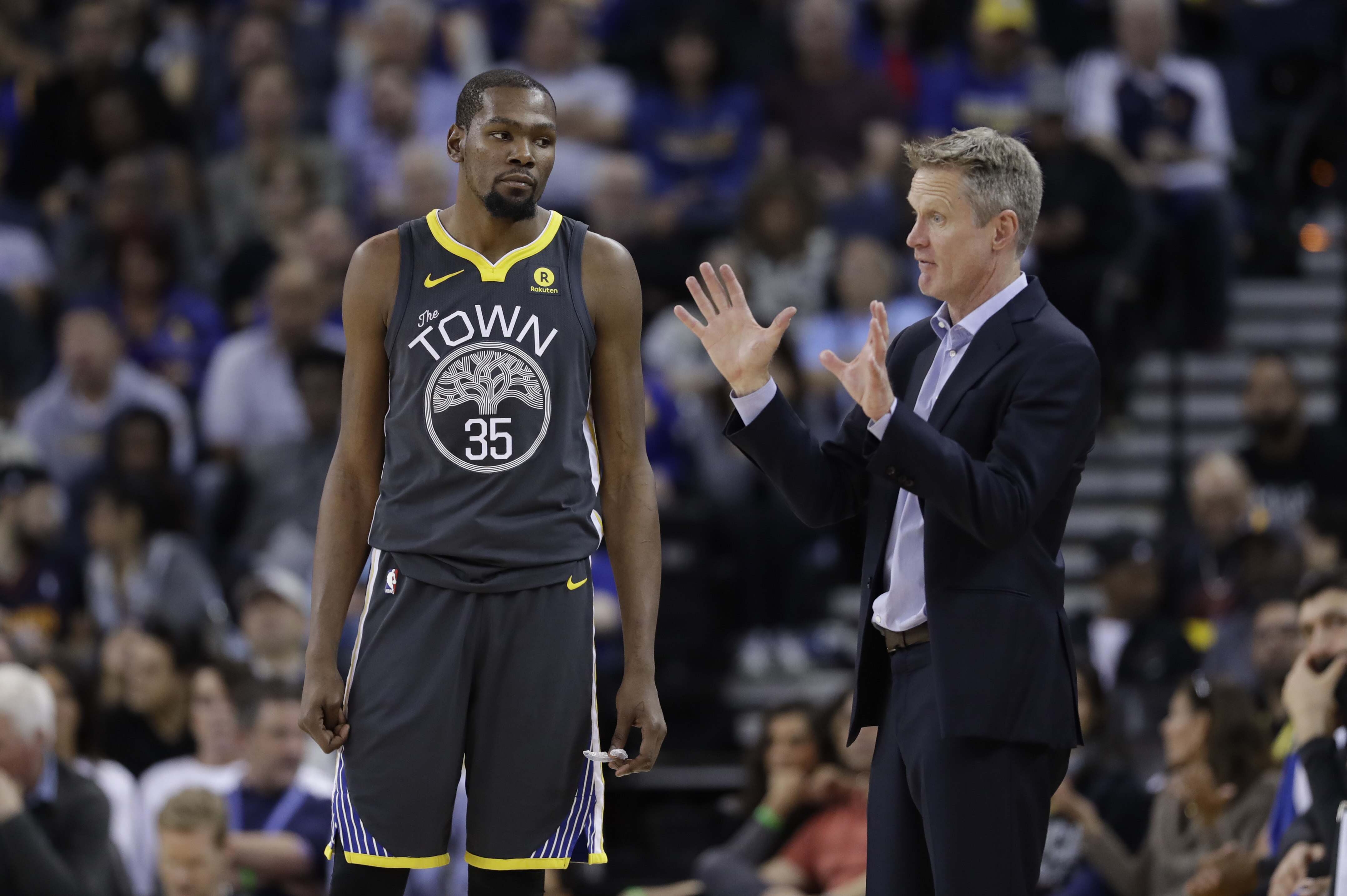 Golden State Warriors head coach Steve Kerr, right, talks to Kevin Durant (35) during the second half of an NBA basketball game against the Oklahoma City Thunder Tuesday, Feb. 6, 2018, in Oakland, Calif. (AP Photo/Marcio Jose Sanchez)