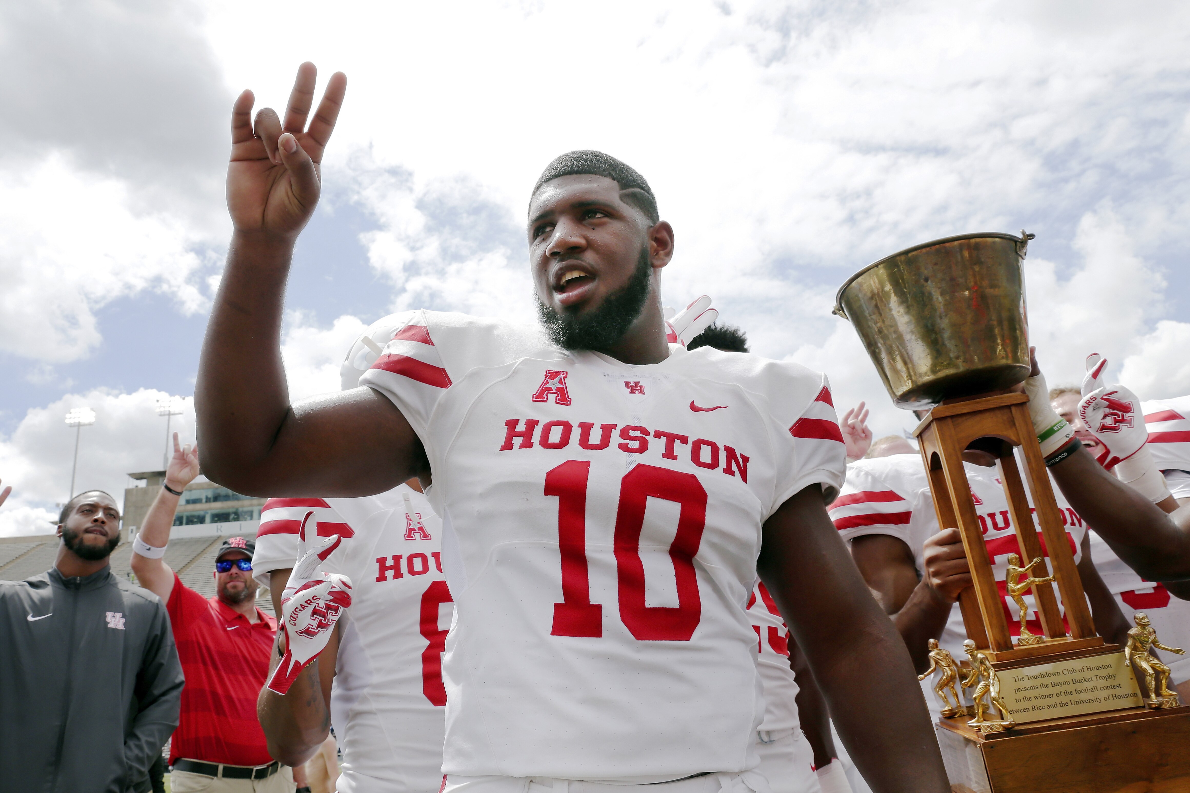 Houston Cougars defensive tackle Ed Oliver does the Cougar Paw with his teammates and the Bayou Bucket trophy after defeating Rice in a NCAA college football game Saturday, Sept. 1, 2018, in Houston. (AP Photo/Michael Wyke)