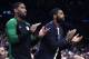 Boston Celtics guard Kyrie Irving, right, who did not play due to an injury, and guard Brad Wanamaker, left, applaud teammates during the first quarter of a basketball game against the New Orleans Pelicans in Boston, Monday, Dec. 10, 2018. (AP Photo/Charles Krupa)