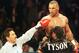 Boxer Mike Tyson of the United States (top R) exhorts Andrew Golota of Poland (not pictured) to continue fighting as referee Frank Garza Jr. raises his hand awarding him a TKO after Golota refused to answer the bell for the third round of their fight at the Palace of Auburn Hills, Michigan, 20 October 2000. This is Tyson's 49th victory in his career. AFP PHOTO Daniel Lippitt (Photo credit should read DANIEL LIPPITT/AFP/Getty Images)