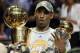 FILE - This is a June 14, 2009, file photo showing Los Angeles Lakers' Kobe Bryant holding the Larry O'Brien championship trophy and finals MVP trophy after the Lakers beat the Orlando Magic 99-86 in Game 5 of the NBA basketball finals, in Orlando, Fla. Bryant was on top when the decade started, and he still is when it ends. Someone so good deserves to be considered among the candidates for The Associated Press' Athlete of the Decade.(AP Photo/David J. Phillip, File)