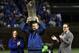 Tom Ricketts, center, with Laura Ricketts and Todd Ricketts, hoists the 2016 World Series Championship trophy before a baseball game between the Chicago Cubs and the Los Angeles Dodgers on a home opening day, Monday, April 10, 2017, in Chicago. (AP Photo/David Banks)