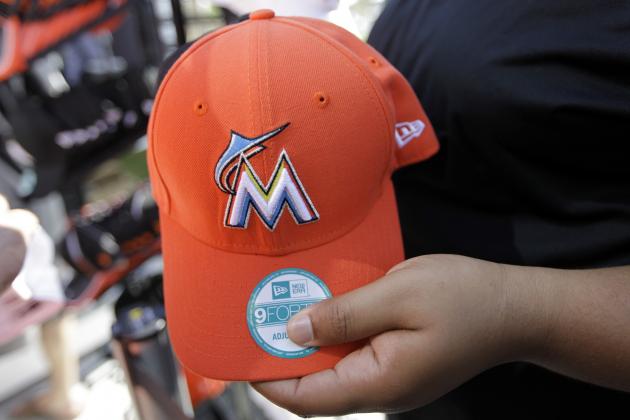 A vendor holds a cap for sale with the new logo of the Florida Marlins before an Opening Day baseball game between the Miami Marlins and St. Louis Cardinals, Wednesday, April 4, 2012, in Miami. (AP Photo/Lynne Sladky)