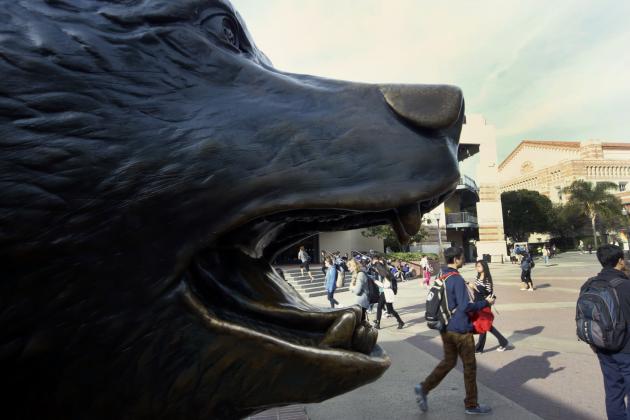 In this Thursday, Feb. 26, 2015 photo, students walk near the UCLA mascot, the Bruin Bear, on the Westwood campus, in Los Angeles. With the University of California system budget having become a political football in the state capital, admissions officers and administrators throughout the UC system still don’t know how many students they can enroll, whether there will be enough money to expand the number from California and if talk about significantly raising tuition for nonresidents will scare off students from outside the state and abroad that campuses have increasingly relied on to make ends meet. (AP Photo/Damian Dovarganes)
