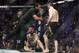 Khabib Nurmagomedov, right, is held back by referee Herb Dean after fighting Conor McGregor, bottom, during a lightweight title mixed martial arts bout at UFC 229 in Las Vegas, Saturday, Oct. 6, 2018. Nurmagomedov won the fight by submission during the fourth round to retain the title. (AP Photo/John Locher)