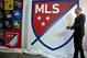 FILE - In this Sept. 18, 2014, file photo, Major League Soccer Commissioner Don Garber launches the league's new logo during a press conference in New York. Garber said Tuesday, Dec 2, 2014, the league is not performing as hoped financially with the league and its franchises still losing more than $100 million combined annually. (AP Photo/Bebeto Matthews)
