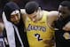 Los Angeles Lakers guard Lonzo Ball, center, is carried off the court by Michael Beasley, left, and Lance Stephenson after Ball sustained an injury during the second half of the team's NBA basketball game against the Houston Rockets, Saturday, Jan. 19, 2019, in Houston. (AP Photo/Eric Christian Smith)