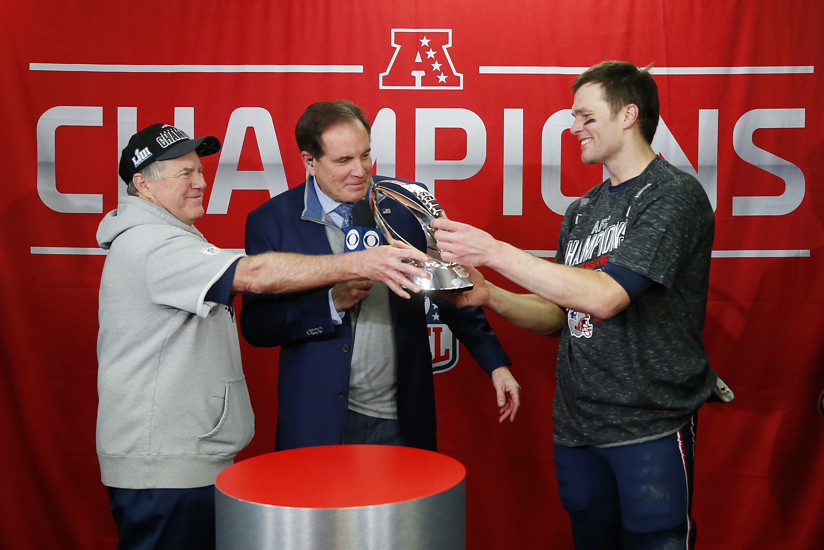 KANSAS CITY, MISSOURI - JANUARY 20: Head coach Bill Belichick of the New England Patriots hands the Lamar Hunt Trophy to Tom Brady #12 after defeating the Kansas City Chiefs during the AFC Championship Game at Arrowhead Stadium on January 20, 2019 in Kansas City, Missouri. The New England Patriots defeated the Kansas City Chiefs 37-31. (Photo by Jamie Squire/Getty Images)