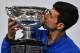Serbia's Novak Djokovic celebrates with the championship trophy during the presentation ceremony after his victory against Spain's Rafael Nadal in the men's singles final on day 14 of the Australian Open tennis tournament in Melbourne on January 27, 2019. (Photo by Paul Crock / AFP) / -- IMAGE RESTRICTED TO EDITORIAL USE - STRICTLY NO COMMERCIAL USE -- (Photo credit should read PAUL CROCK/AFP/Getty Images)