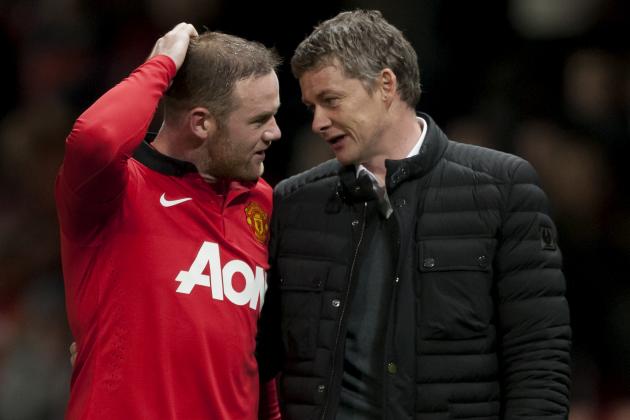 Manchester United's Wayne Rooney, left, walks from the pitch with Cardiff City's manager Ole Gunnar Solskjaer after their English Premier League soccer match at Old Trafford Stadium, Manchester, England, Tuesday Jan. 28, 2014. (AP Photo/Jon Super)