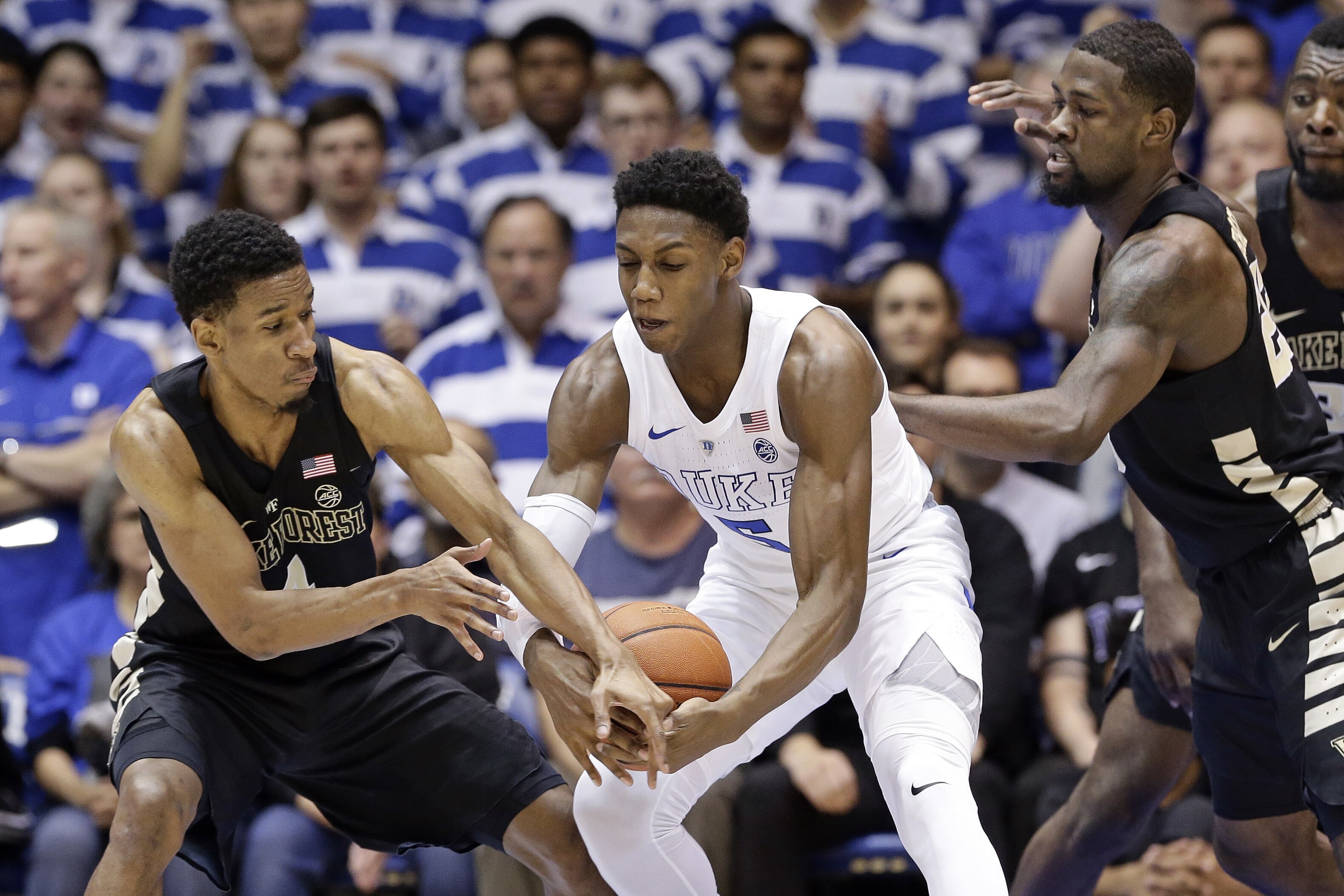 Duke's RJ Barrett, center, reaches for the ball between Wake Forest's Torry Johnson, left, and Chaundee Brown during the first half of an NCAA college basketball game in Durham, N.C., Tuesday, March 5, 2019. (AP Photo/Gerry Broome)