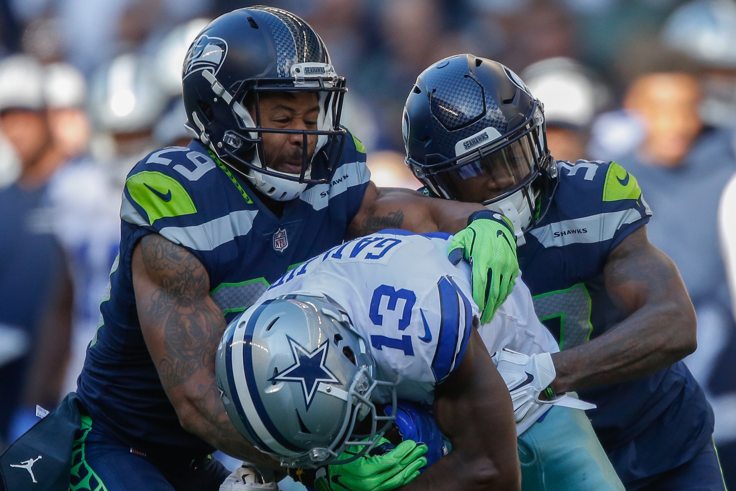 SEATTLE, WA - SEPTEMBER 23: Wide receiver Michael Gallup #13 of the Dallas Cowboys is tackled by free safety Earl Thomas #29 and cornerback Tre Flowers #37 of the Seattle Seahawks at CenturyLink Field on September 23, 2018 in Seattle, Washington. (Photo by Otto Greule Jr/Getty Images)