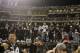 Fans stand on a dugout at Oakland Alameda County Coliseum after an NFL football game between the Oakland Raiders and the Denver Broncos in Oakland, Calif., Monday, Dec. 24, 2018. (AP Photo/John Hefti)