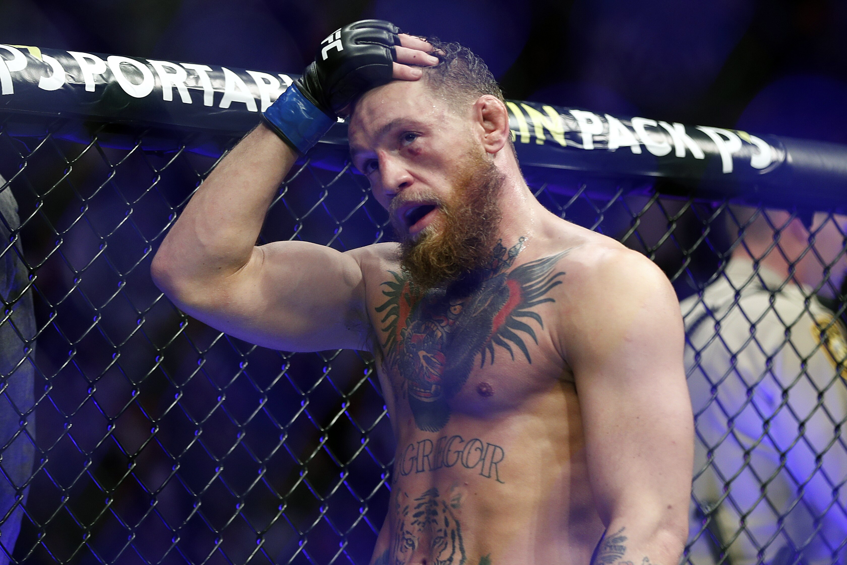 FILE - In this Oct. 6, 2018, file photo, Conor McGregor reacts after losing to Khabib Nurmagomedov in a lightweight title mixed martial arts bout at UFC 229 in Las Vegas. Nurmagomedov was fined $500,000 and suspended for nine months for a brawl inside and outside the octagon after his fight with Conor McGregor at UFC 229. McGregor was fined $50,000 and suspended for six months.  The suspensions for both fighters are retroactive to Oct. 6. (AP Photo/John Locher, File)