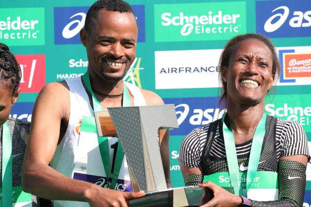Ethiopia's Abrha Milaw (L) and Ethiopia's Gelete Burka celebrate their victory in the men and women category during the podium ceremony of Paris Marathon on April 14, 2019. (Photo by KENZO TRIBOUILLARD / AFP) (Photo credit should read KENZO TRIBOUILLARD/AFP/Getty Images)