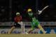 PORT OF SPAIN, TRINIDAD AND TOBAGO - AUGUST 10: In this handout image provided by CPL T20, Andre Russell of Jamaica Tallawahs hits six runs as Denesh Ramdin of Trinbago Knight Riders looks on during the Hero Caribbean Premier League match between Trinbago Knight Riders and Jamaica Tallawahs at Queen's Park Oval on August 10, 2018 in Port of Spain, Trinidad And Tobago. (Photo by Ashley Allen - CPL T20/Getty Images)