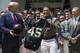 President Donald Trump accepts a jersey from Army running back Darnell Woolfolke Army during the presentation of the Commander-in-Chief's Trophy to the U.S. Military Academy at West Point football team in the Rose Garden of the White House, Monday, May 6, 2019, in Washington. (AP Photo/Alex Brandon)