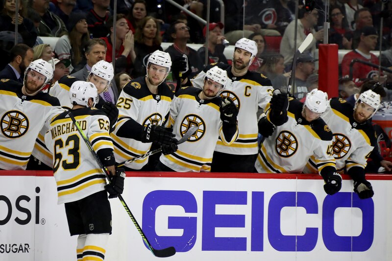 RALEIGH, NORTH CAROLINA - MAY 14: Brad Marchand #63 of the Boston Bruins celebrates with his teammates after scoring a goal on Curtis McElhinney #35 of the Carolina Hurricanes during the second period in Game Three of the Eastern Conference Finals during the 2019 NHL Stanley Cup Playoffs at PNC Arena on May 14, 2019 in Raleigh, North Carolina. (Photo by Bruce Bennett/Getty Images)