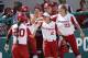 FILE - In this Feb. 15, 2019, file photo, Oklahoma's Caleigh Clifton (20), Sydney Romero (2) and Parker Conrad (73) celebrate during an NCAA college softball game against Florida State in Clearwater, Fla. Oklahoma has matched the Division I record for consecutive wins in a season with 38 and can break the record Friday in the Big 12 Tournament against Texas Tech. The Sooners have done it with talent, balance and a business-like approach. (AP Images/Casey Brooke Lawson via AP, File)