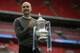 Manchester City's manager Pep Guardiola poses for a picture as lifts the trophy after winning the English FA Cup Final soccer match between Manchester City and Watford at Wembley stadium in London, Saturday, May 18, 2019. Manchester City won 6-0. (AP Photo/Tim Ireland)