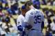 Los Angeles Dodgers manager Dave Roberts, left, talks with Cody Bellinger after Bellinger hit a fan with a foul ball during the first inning of a baseball game against the Colorado Rockies, Sunday, June 23, 2019, in Los Angeles. (AP Photo/Mark J. Terrill)