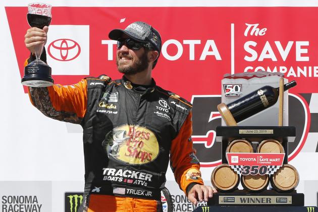 SONOMA, CALIFORNIA - JUNE 23: Martin Truex Jr., driver of the #19 Bass Pro Shops Toyota, poses with the trophy in Victory Lane after winning the Monster Energy NASCAR Cup Series Toyota/Save Mart 350 at Sonoma Raceway on June 23, 2019 in Sonoma, California. (Photo by Jonathan Ferrey/Getty Images)