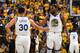 OAKLAND, CA - APRIL 28: Stephen Curry #30 of the Golden State Warriors high-fives Kevin Durant #35 of the Golden State Warriors against the Houston Rockets during the Western Conference Semifinals of the NBA Playoffs on April 28, 2019 at ORACLE Arena in Oakland, California. NOTE TO USER: User expressly acknowledges and agrees that, by downloading and or using this photograph, user is consenting to the terms and conditions of Getty Images License Agreement. Mandatory Copyright Notice: Copyright 2019 NBAE (Photo by Andrew D. Bernstein/NBAE via Getty Images)