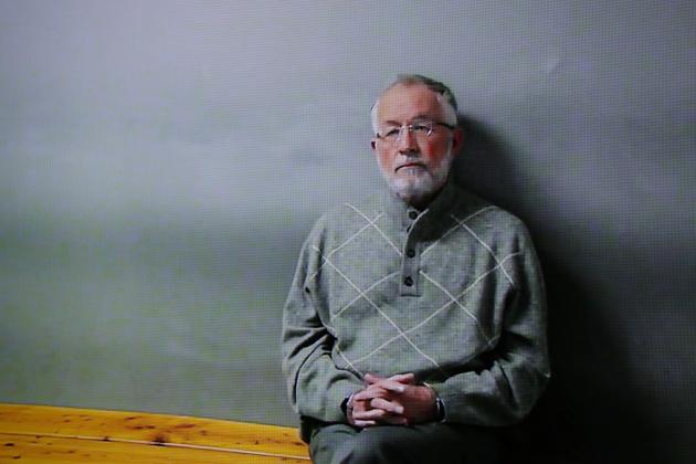 William Strampel appears on a monitor during his video arraignment, Tuesday, March 27, 2018, in East Lansing, Mich. Strampel, a Michigan State University official who oversaw Larry Nassar, was arrested Monday amid an investigation into the handling of complaints against the former sport doctor, who is in prison for sexually assaulting patients under the guise of treatment. (AP Photo/Paul Sancya)