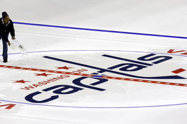 Philip Westmoreland throws water on the Washington Capitals logo at center ice as the logos are placed and the lines painted in preparation for the upcoming NHL hockey season at Verizon Center, Wednesday, Jan. 9, 2013, in Washington. (AP Photo/Alex Brandon)