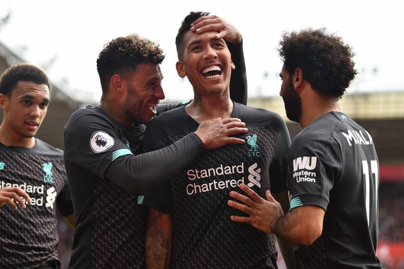 Liverpool's Brazilian midfielder Roberto Firmino (C) celebrates with teammates after scoring their second goal during the English Premier League football match between Southampton and Liverpool at St Mary's Stadium in Southampton, southern England on August 17, 2019. (Photo by Glyn KIRK / AFP) / RESTRICTED TO EDITORIAL USE. No use with unauthorized audio, video, data, fixture lists, club/league logos or 'live' services. Online in-match use limited to 120 images. An additional 40 images may be used in extra time. No video emulation. Social media in-match use limited to 120 images. An additional 40 images may be used in extra time. No use in betting publications, games or single club/league/player publications. /         (Photo credit should read GLYN KIRK/AFP/Getty Images)