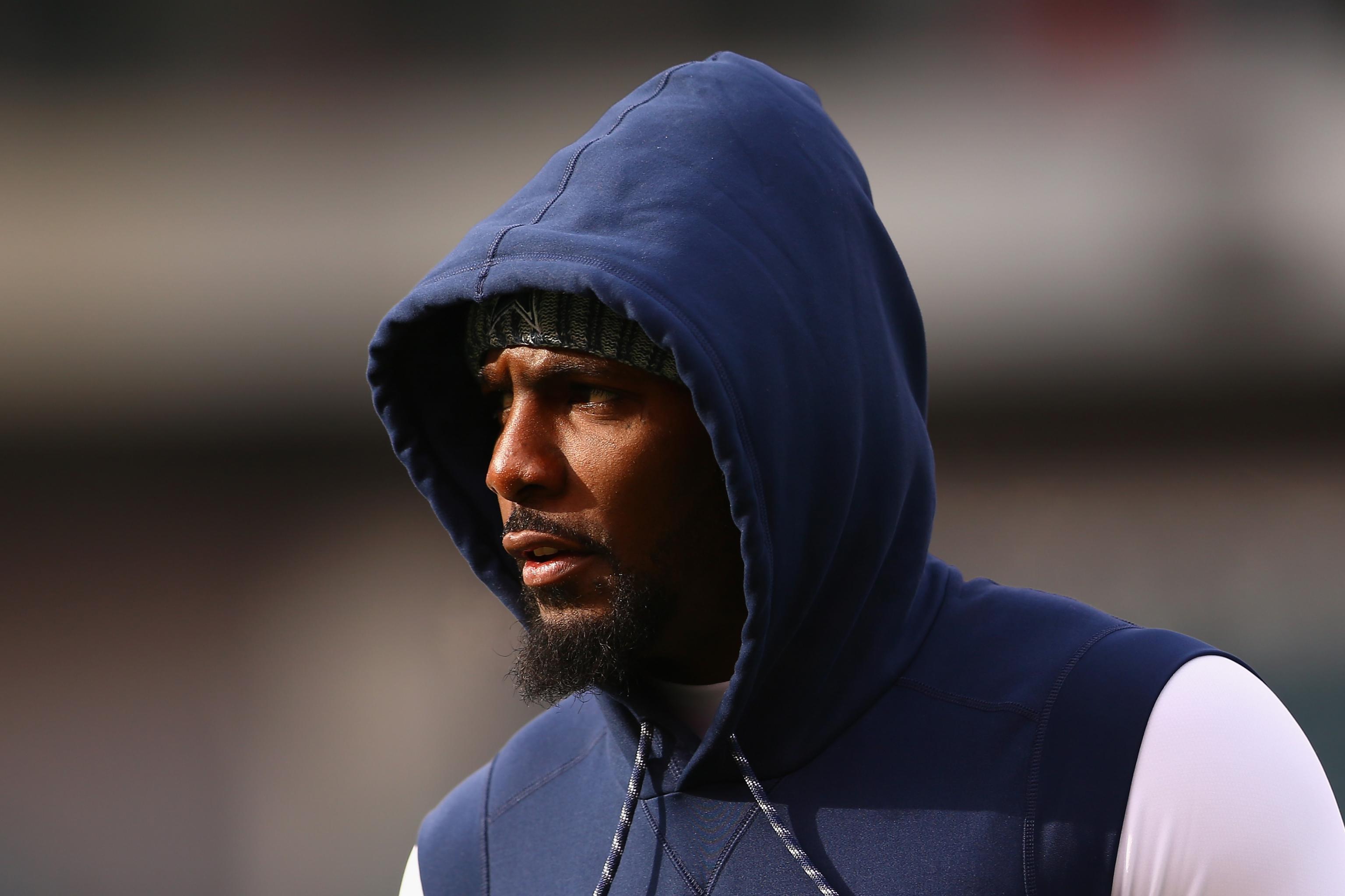 Why is Ezekiel Elliott wearing a hooded sweatshirt during practice?