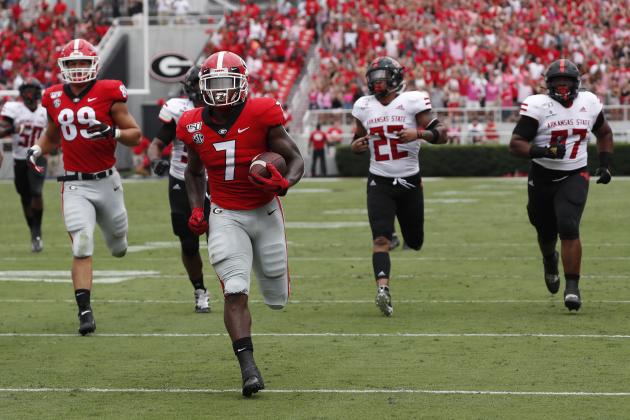 Georgia running back D'Andre Swift (7) is chased by the Arkansas State defense as he scores a touchdown in the first half of an NCAA college football game Saturday, Sept. 14, 2019, in Athens, Ga. (AP Photo/John Bazemore)