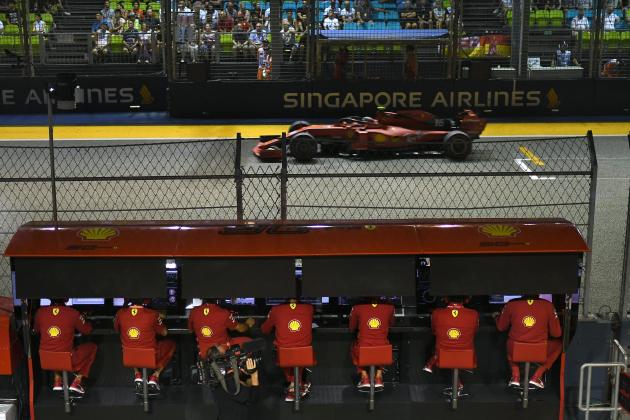 Ferrari's Monegasque driver Charles Leclerc (top) drives past the Ferrari team as he takes part in the qualifying session for the Formula One Singapore Grand Prix at the Marina Bay Street Circuit in Singapore on September 21, 2019. (Photo by Mohd RASFAN / AFP)        (Photo credit should read MOHD RASFAN/AFP/Getty Images)