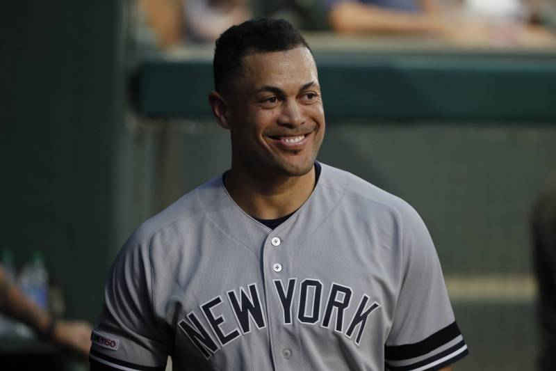 New York Yankees' Giancarlo Stanton stands in the dugout after hitting a solo home run against the Texas Rangers in the first inning of a baseball game in Arlington, Texas, Friday, Sept. 27, 2019. (AP Photo/Tony Gutierrez)