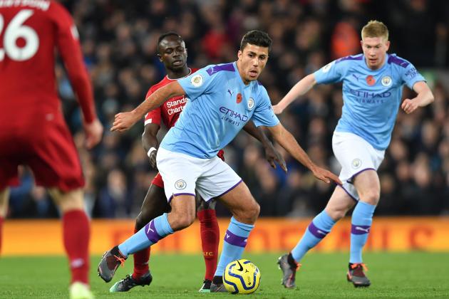 Manchester City's Spanish midfielder Rodri (C) vies with Liverpool's Senegalese striker Sadio Mane (L) during the English Premier League football match between Liverpool and Manchester City at Anfield in Liverpool, north west England on November 10, 2019. (Photo by Paul ELLIS / AFP) / RESTRICTED TO EDITORIAL USE. No use with unauthorized audio, video, data, fixture lists, club/league logos or 'live' services. Online in-match use limited to 120 images. An additional 40 images may be used in extra time. No video emulation. Social media in-match use limited to 120 images. An additional 40 images may be used in extra time. No use in betting publications, games or single club/league/player publications. /  (Photo by PAUL ELLIS/AFP via Getty Images)
