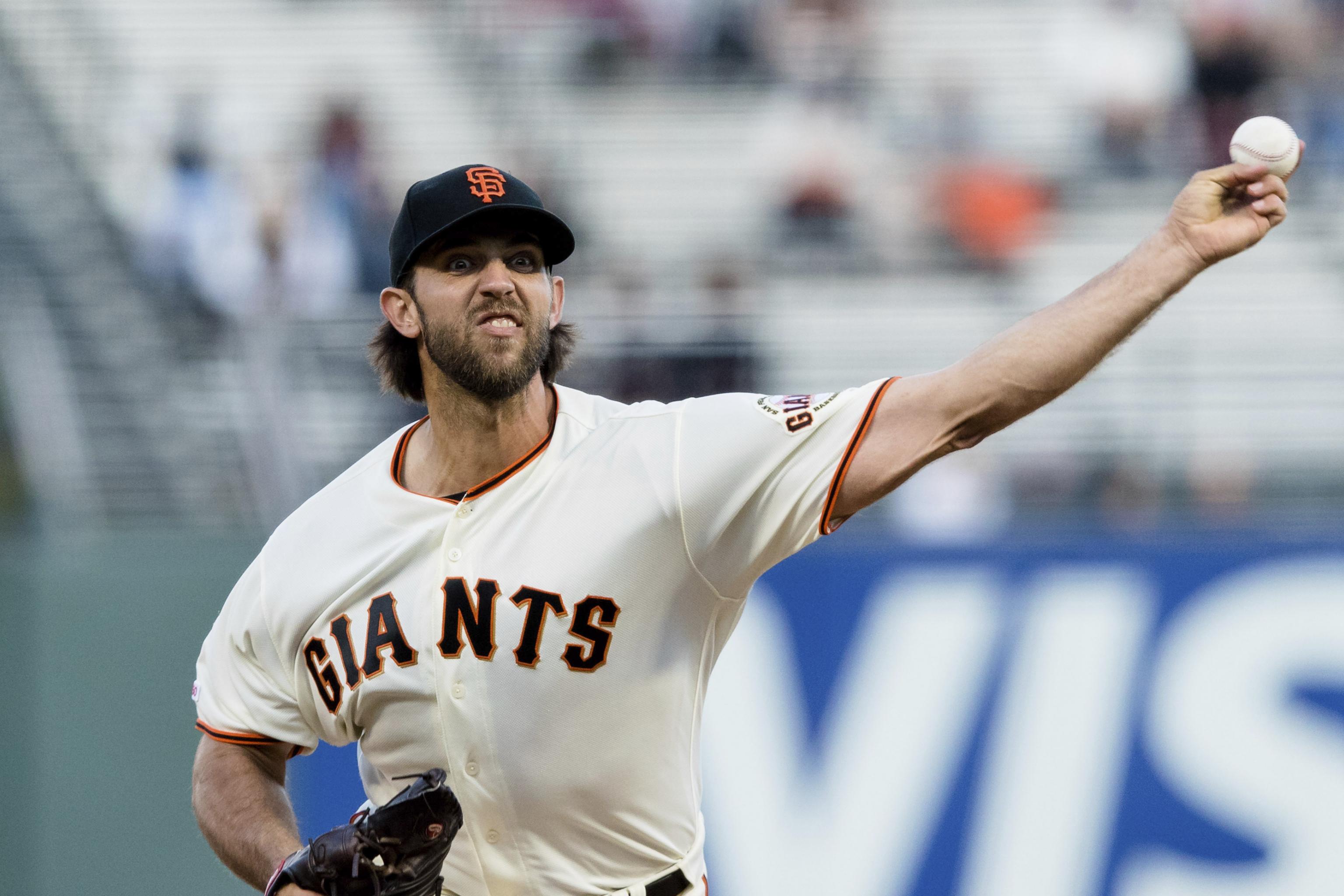 San Francisco Giants starting pitcher Madison Bumgarner touches his beard  as he walks back to the mound while working against the San Diego Padres  during the third inning of a baseball game